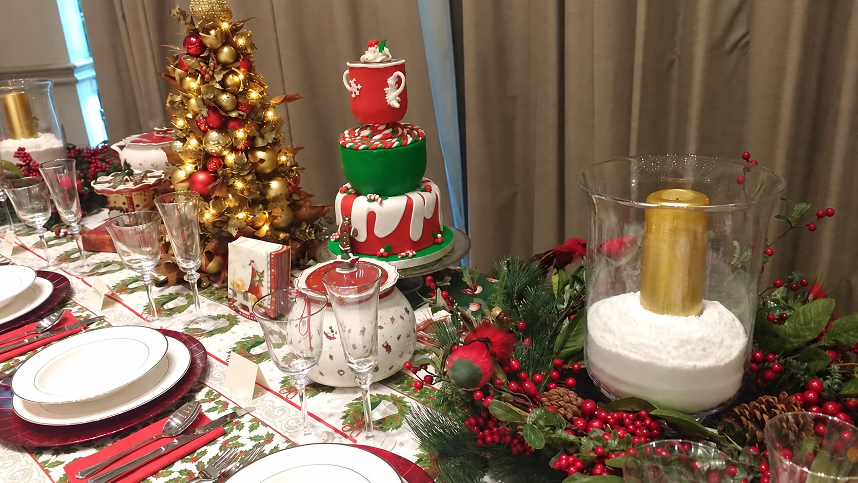 Mesa navideña con árbol iluminado, velas y frutos rojos