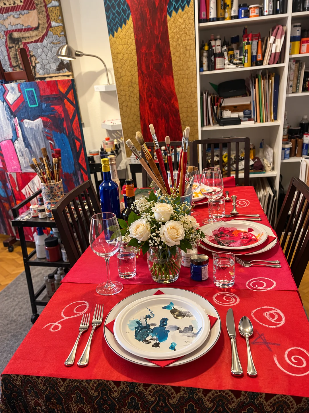 Mesa del artista con pinceles, pigmentos y rosas blancas